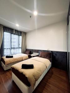 a bedroom with two beds and a window at Harmony Homes at i-City - free WiFi and 1 Car Park in Shah Alam