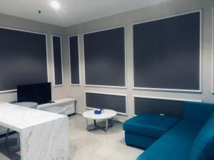 a living room with a blue couch and a table at Glass Homes at i-City - WiFi TV Box and 1 Carpark in Shah Alam