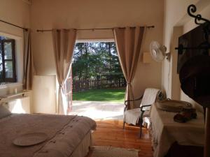 a bedroom with two beds and a door to a yard at VILLa ENRIETTe - Panoramic Mountain Retreat in Pano Platres, Cyprus in Kato Platres