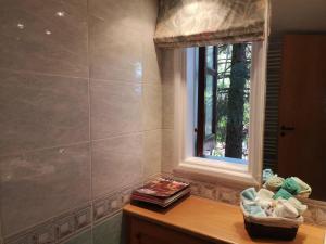 a bathroom with a window and a table with towels at VILLa ENRIETTe - Panoramic Mountain Retreat in Pano Platres, Cyprus in Kato Platres +13 photos