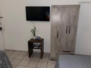 a bedroom with a wooden cabinet and a table with a tv at bamboo bed and breakfast in San Pedro Sula