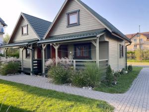 a house with a pathway in front of it at Domki Balos in Karwia