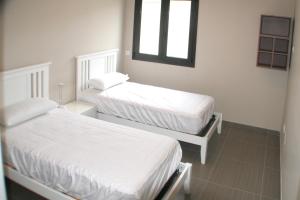 two white beds in a room with a window at Presciosa Villa Jupiter SOLO FAMILIAS in Cambrils +12 photos