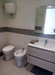 a bathroom with a toilet and a sink at Ascanio Appartamenti in Castiglione del Lago +16 photos