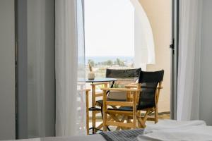 a room with a balcony with a table and chairs at Scala Apartments in Kastraki