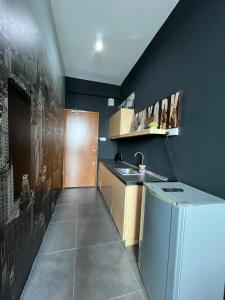 a small kitchen with a sink and a refrigerator at Comfy Empire Damansara Studio in Petaling Jaya