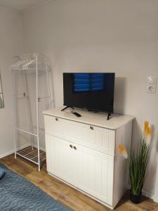 a tv on top of a white cabinet in a room at Napsugár vendégház in Tahitótfalu