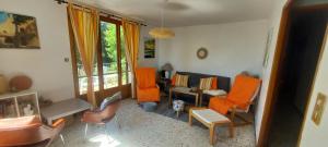 a living room with orange chairs and a couch at Villa Maison de campagne 04 Vacheres Luberon 3 chambres 8 personnes in Vachères