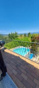 a metal fence with a pool with blue water at Villa Maison de campagne 04 Vacheres Luberon 3 chambres 8 personnes in Vachères