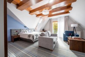 a bedroom with a bed and a couch and a chair at Hotel Willa Pod Skocznią in Zakopane +96 photos
