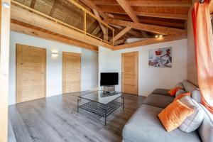 a living room with a couch and a tv at Gite la Quintessence in Nonglard