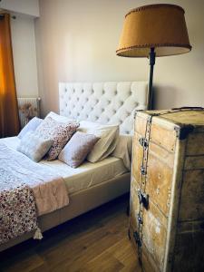 ein Schlafzimmer mit einem Bett mit einer Lampe und einer alten Truhe in der Unterkunft Appartement face à la mer in Santa-Maria-di-Lota