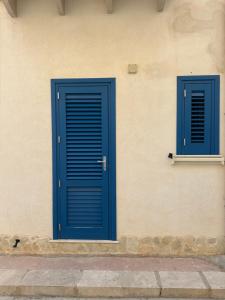two blue doors on the side of a building at Cabina Da Mare in Marettimo +7 photos