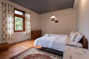 un dormitorio con una cama y una ventana en Unwind at Chanderlok, en Nagar