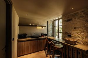 a kitchen with a counter with chairs and a microwave at Lecole Hotel By Cityloft in Yenifoça