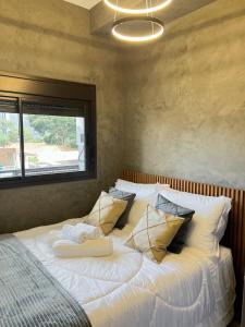 a bedroom with a bed with pillows and a window at Cozy and complete studio - Brooklin SP in Sao Paulo