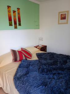 a bedroom with a bed with a blue blanket at Chayerita - Suite en La Rioja in La Rioja
