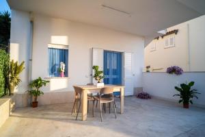 een tafel en stoelen in een kamer met planten bij Casa vacanze CaMi in Alcamo