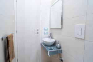een badkamer met een wastafel en een spiegel bij Casa vacanze CaMi in Alcamo +16 foto's