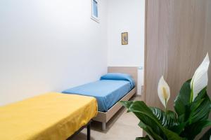 een slaapkamer met 2 bedden en een plant bij Casa vacanze CaMi in Alcamo