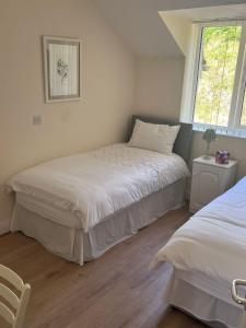 a bedroom with two beds and a window at 2 bed Beachfront Apartment Inchydoney Cork in Balnacart