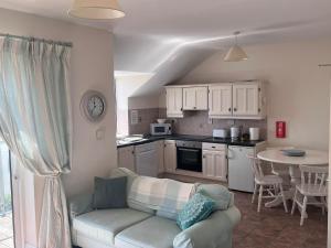 a living room with a couch and a kitchen at 2 bed Beachfront Apartment Inchydoney Cork in Cork
