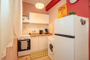 a kitchen with a refrigerator and a washer and dryer at Yiayia's Guesthouse in Ipsos