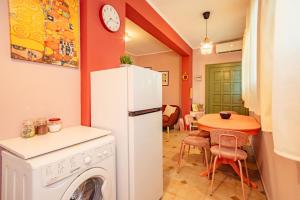 a kitchen with a white refrigerator and a table at Yiayia's Guesthouse in Ipsos +30 photos
