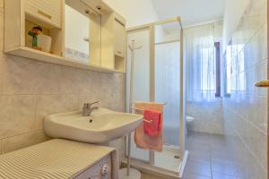 a bathroom with a sink and a shower at Rose's House in Trinità dʼAgultu +15 photos