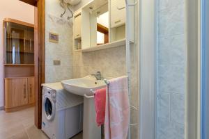 a bathroom with a sink and a washing machine at Rose's House in Trinità dʼAgultu