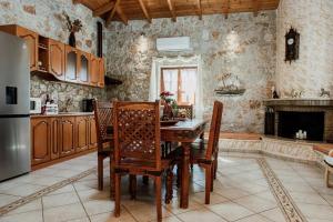 cocina con mesa, sillas y chimenea en Aigli Villa Drepano, en Dhrepanon