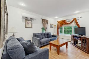 un salon avec deux canapés et une télévision dans l'établissement Dogwood Cottage, à Bar Harbor