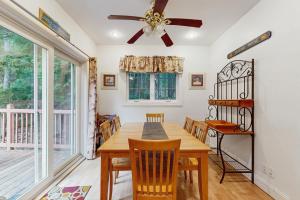 une salle à manger avec une table et des chaises et un ventilateur de plafond dans l'établissement Dogwood Cottage, à Bar Harbor