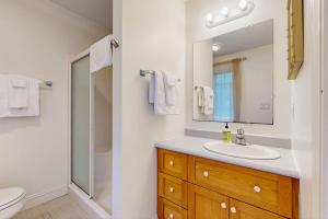 une salle de bain avec un lavabo, des toilettes et un miroir dans l'établissement Dogwood Cottage, à Bar Harbor 18 autres photos