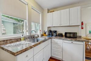 una cucina con mobili bianchi, un lavello e un microonde di Norris Cottage a Bar Harbor
