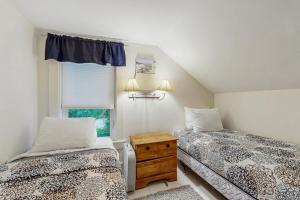 una camera da letto con due letti e una finestra di Norris Cottage a Bar Harbor