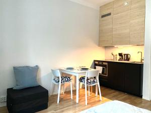 a small kitchen with a table and chairs in a room at Simply chic Kamppi !NEW! in Helsinki