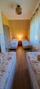 a room with three beds in a room with a ceiling at Dom na wyłączność U Eskulapa in Lutowiska