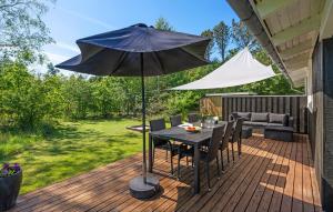 una mesa con una sombrilla en una terraza en Lovely Home In Jerup With Kitchen, en Jerup 22 fotos más