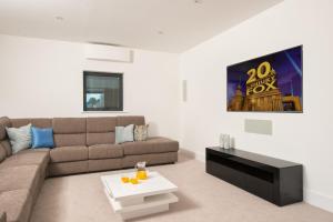 een woonkamer met een bank en een tafel bij The Cotswolds Manor ML26 Lower Mill Estate. in Somerford Keynes