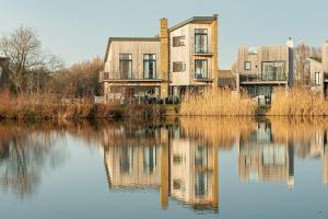 een gebouw naast een waterlichaam bij The Cotswolds Manor ML26 Lower Mill Estate. in Somerford Keynes