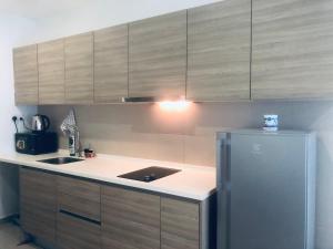 a kitchen with a sink and a refrigerator at Luxe Homes at i-City - WiFi TV Box & 1 Carpark in Shah Alam