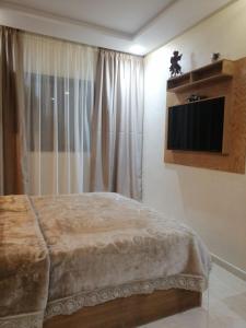a bedroom with a bed and a television on the wall at ميرمار in Tétouan