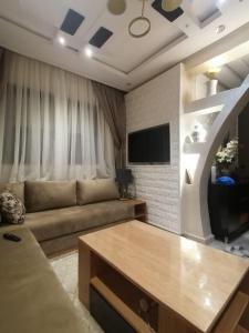 a living room with a couch and a flat screen tv at ميرمار in Tétouan