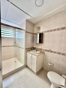 a bathroom with a toilet and a sink and a shower at Casa hotel la 33 in Medellín +72 photos
