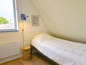 a small bedroom with a bed and a window at Vakantiehuis Domburg DO60 in Domburg