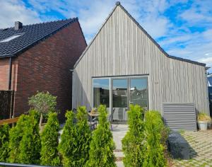 a barn conversion with glass doors and a brick building at Vakantiehuis Domburg DO60 in Domburg