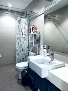 a bathroom with a white sink and a toilet at Maple Homes at i-City - WiFi TV Box and 1 Carpark in Shah Alam +11 photos