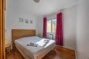 a bedroom with a bed and a window with red curtains at Le Bassin in Port-en-Bessin-Huppain