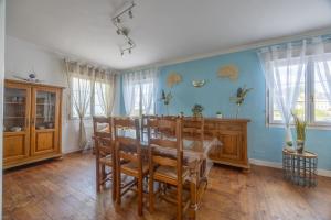 a dining room with a table and chairs and blue walls at Le Bassin in Port-en-Bessin-Huppain +11 photos